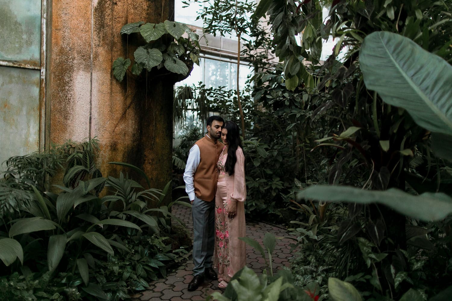 A couple posing in a greenhouse at Atlanta Botanical Gardens.