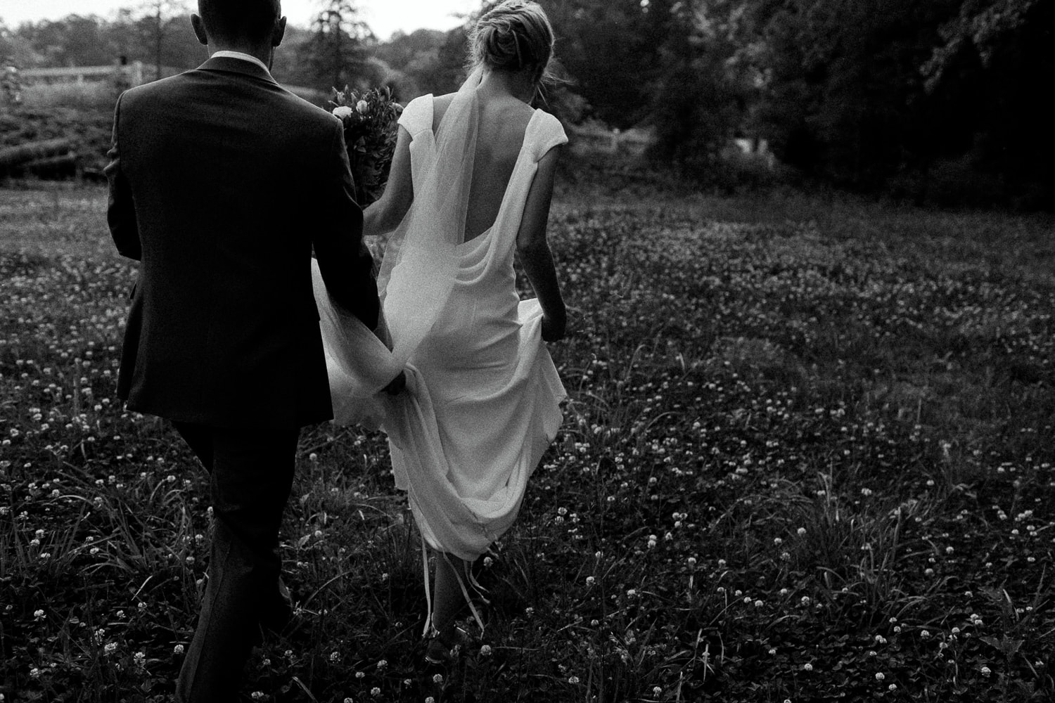 A couple walking through a field at The Greystone Estate, a North Georgia wedding venue.