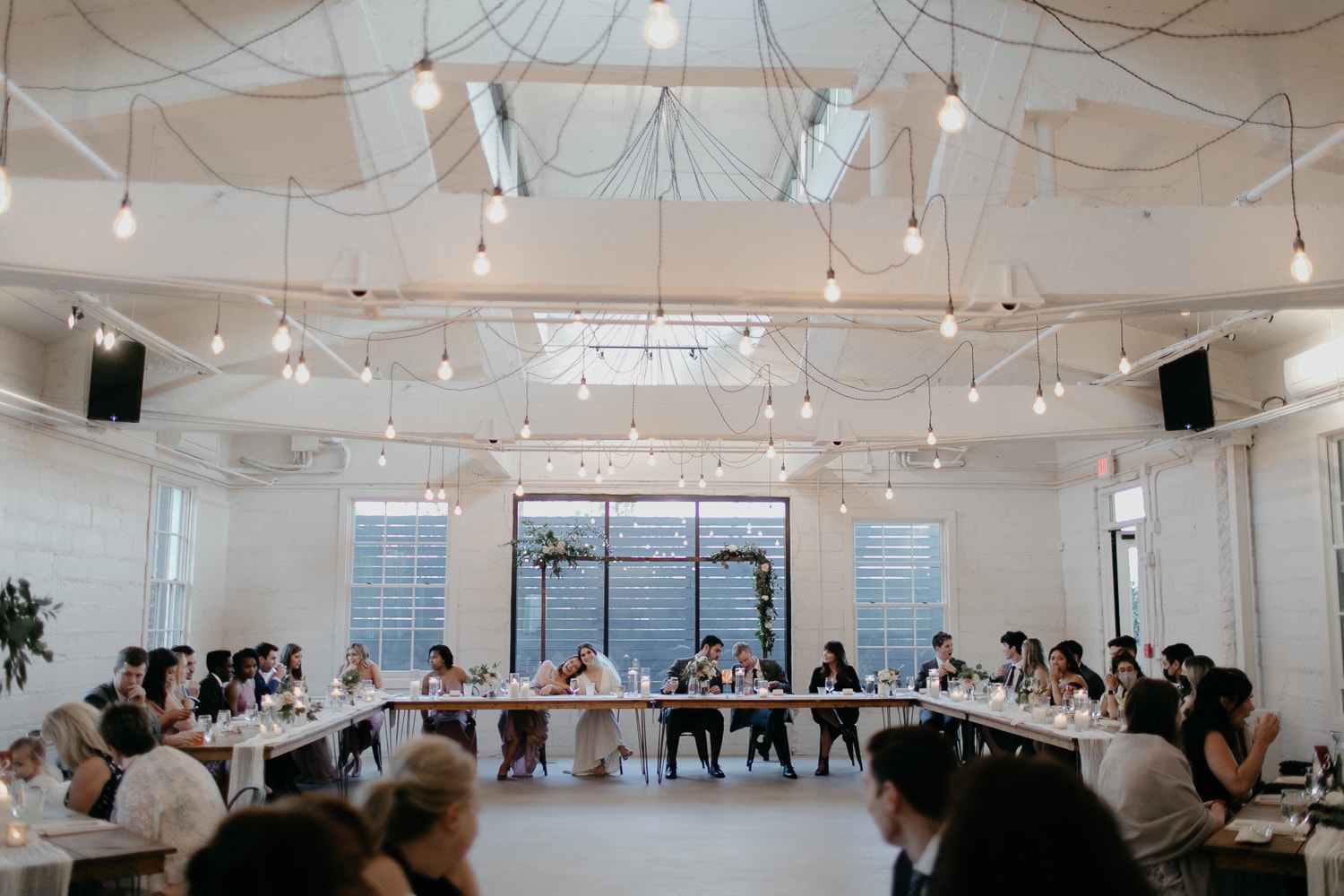 A modern wedding reception with long tables at Upstairs Atlanta wedding venue.