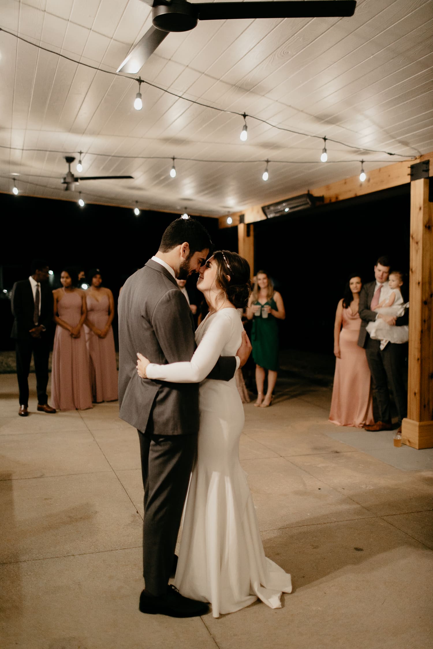 A couple sharing their wedding dance in the outdoor pavilion area at Upstairs Atlanta wedding venue.